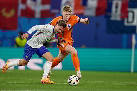 Antoine Griezmann tussles for the ball with Jerdy Schouten